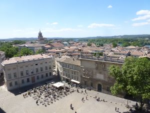 Vista dal tetto del Palazzo verso Place du Palais e i tetti di Avignone: a destra l'Hôtel des Monnais e a sinistra la torre dell'orologio